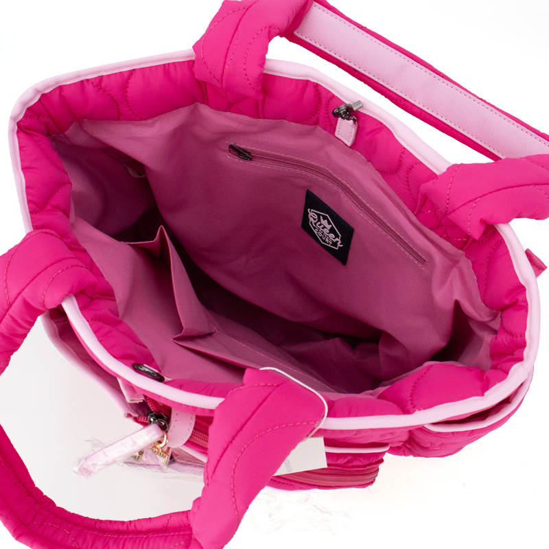 A top-down view of the Queen of the Court Fifth Ave Pickleball Convertible Tote Bag/Backpack in bright pink, featuring padded handles, a light pink lined interior with zip and open pockets, plus a black Queen of the Court logo tag—spacious and organized.