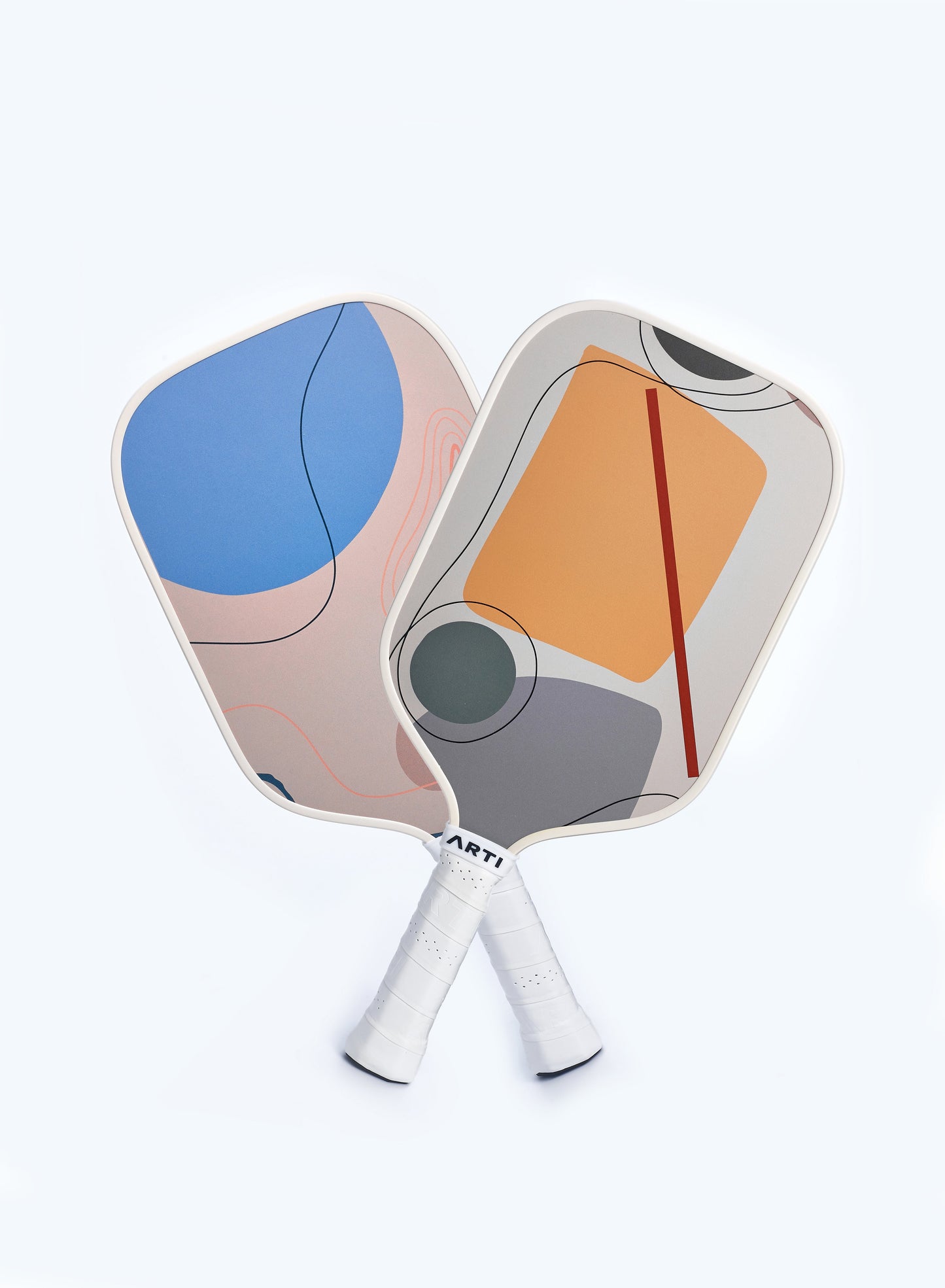 ARTI Fiberglass "Horizon Duo" Pickleball Paddle Set by ARTI features two USAPA approved paddles with white handles: one with abstract blue, beige, and peach shapes, the other with geometric orange, gray, and red designs on a light gray background.