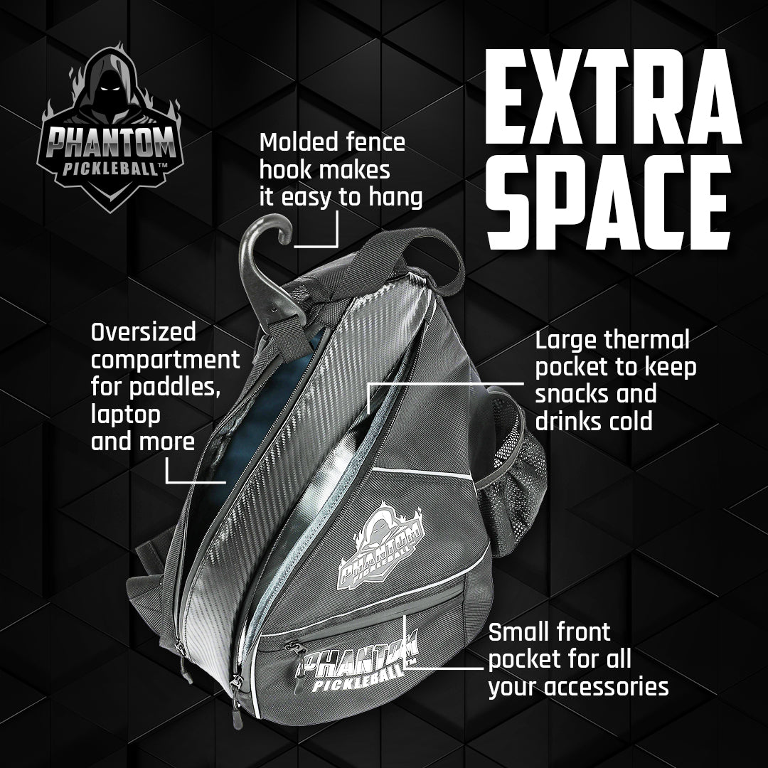 The Phantom Pickleball Sling Bag by Phantom Pickleball is shown in black, featuring an oversized paddle/gear compartment, molded fence hook, large thermal pocket for snacks or drinks, and a small front accessory pocket with labeled features.