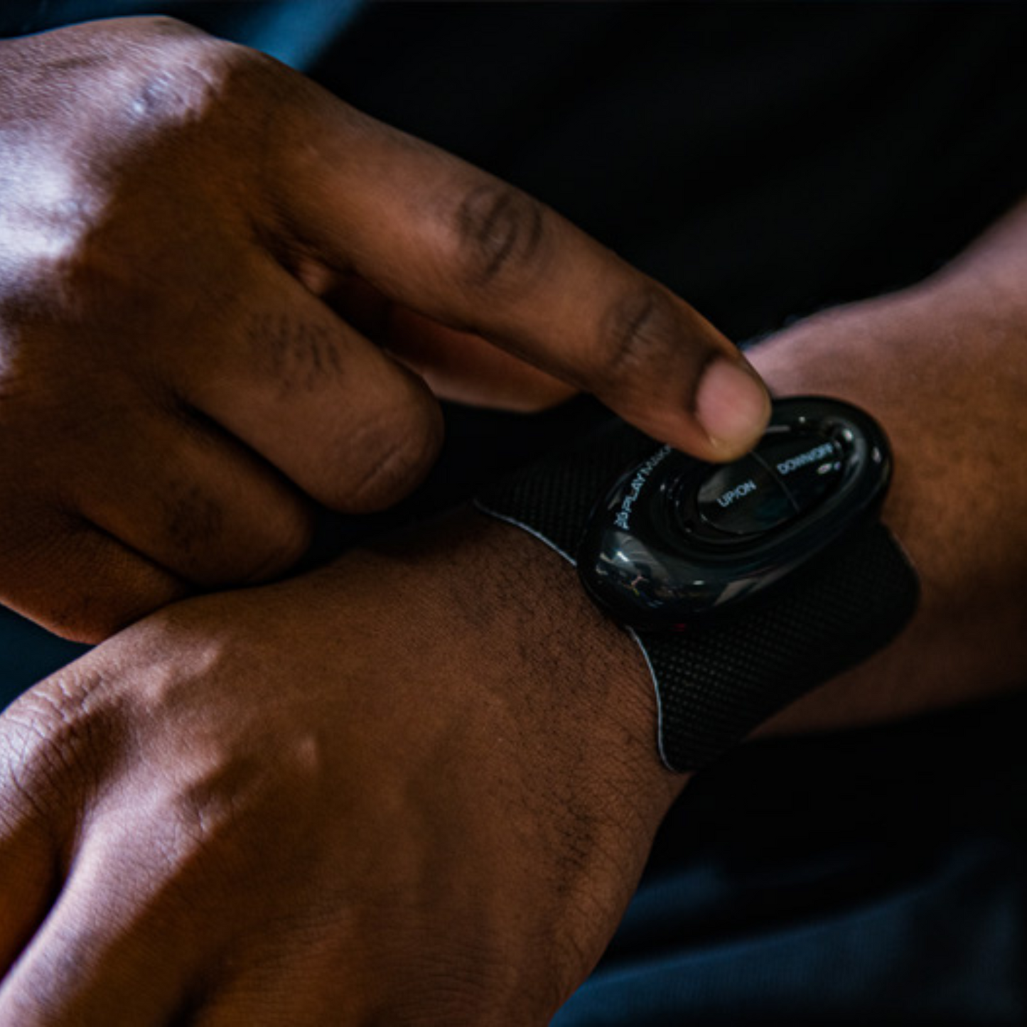 A close-up shows a person pressing a button on a black TENS device strapped to their wrist, highlighting muscle groups targeted by iReliev Premium WiTENS Electrode Pads (3 CT) against a dark background.