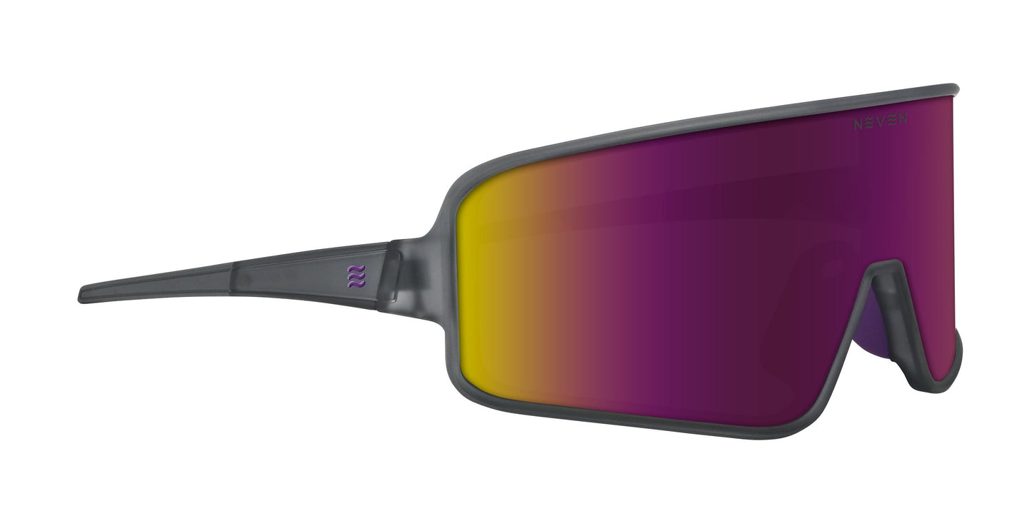 Neven Eyewear’s Mattingly sunglasses feature a single oversized shield lens in a yellow-to-purple gradient, vintage baseball-inspired. The minimal matte gray frame wraps the lens, with a purple logo on the left temple and integrated nosepiece.
