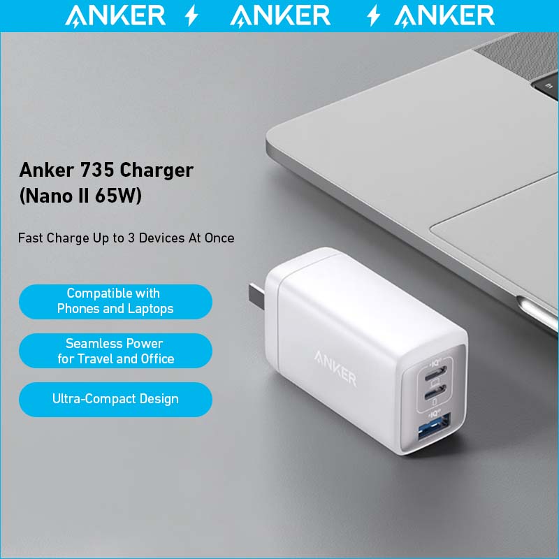 A white Anker 735 Charger (Nano II 65W) (2-Pack) with three ports is displayed on a gray surface beside a laptop, featuring fast charging, advanced GaN II tech, broad device compatibility, and an ultra-compact travel design.