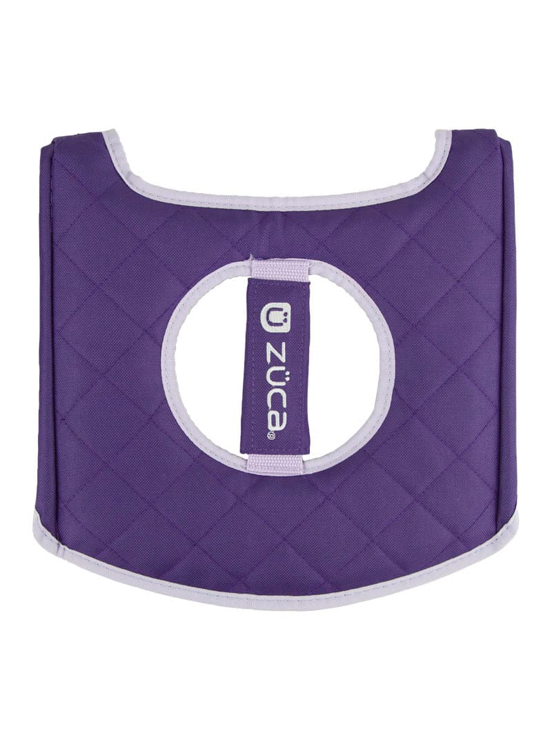The ZUCA Reversible Seat Cushion is a purple, quilted accessory with white trim, a round center hole, and a vertical “züca” logo strip. Padded for comfort, it’s shown lying flat on a white background.