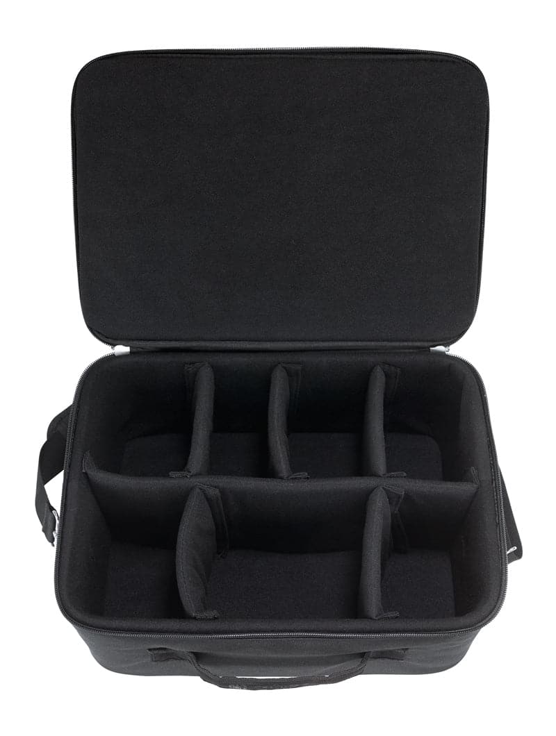 The ZUCA Tech Case is a black, soft-sided case with a zipper closure, front handle, and an open lid revealing six compartments with padded dividers for organized storage and transport of equipment or accessories.