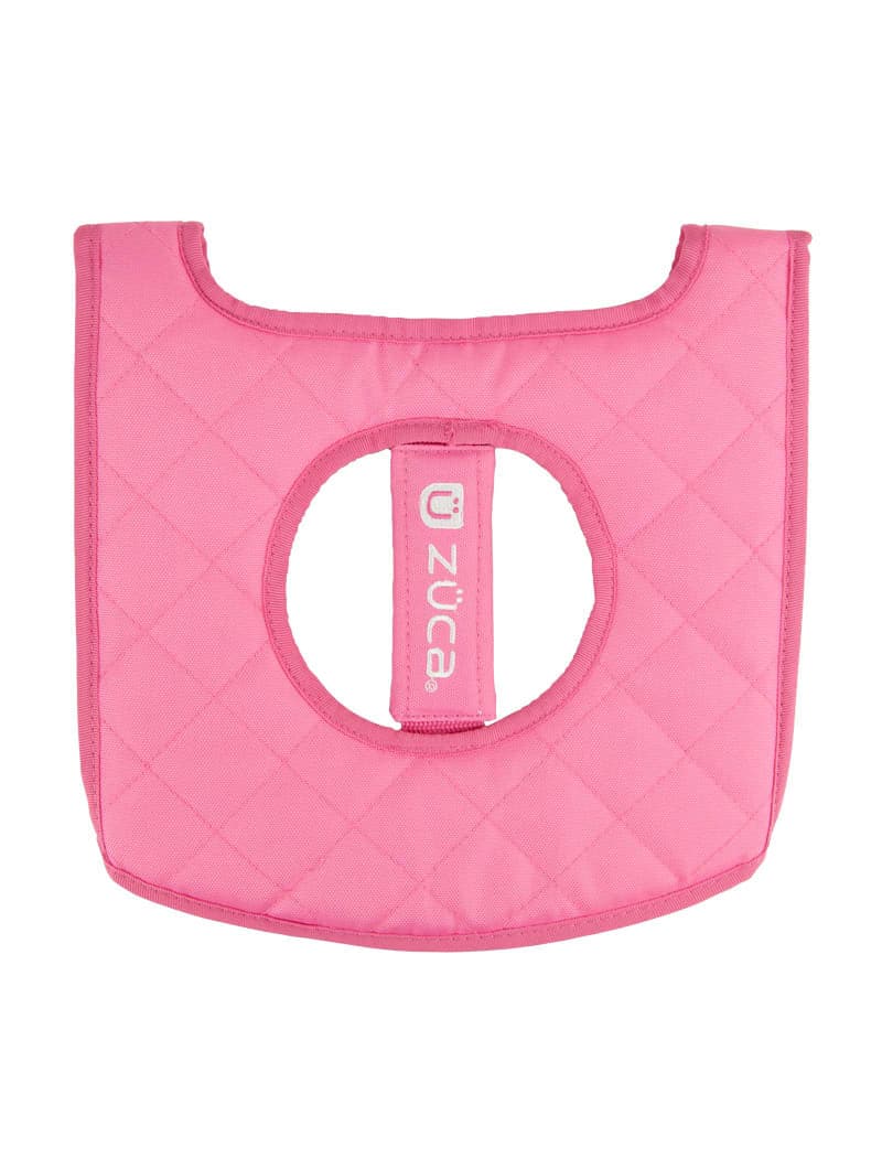 The ZUCA Reversible Seat Cushion is a quilted, bright pink accessory with a central rounded cutout, curved edges, diamond stitching, and a vertical strap featuring the ZUCA logo for a secure fit.