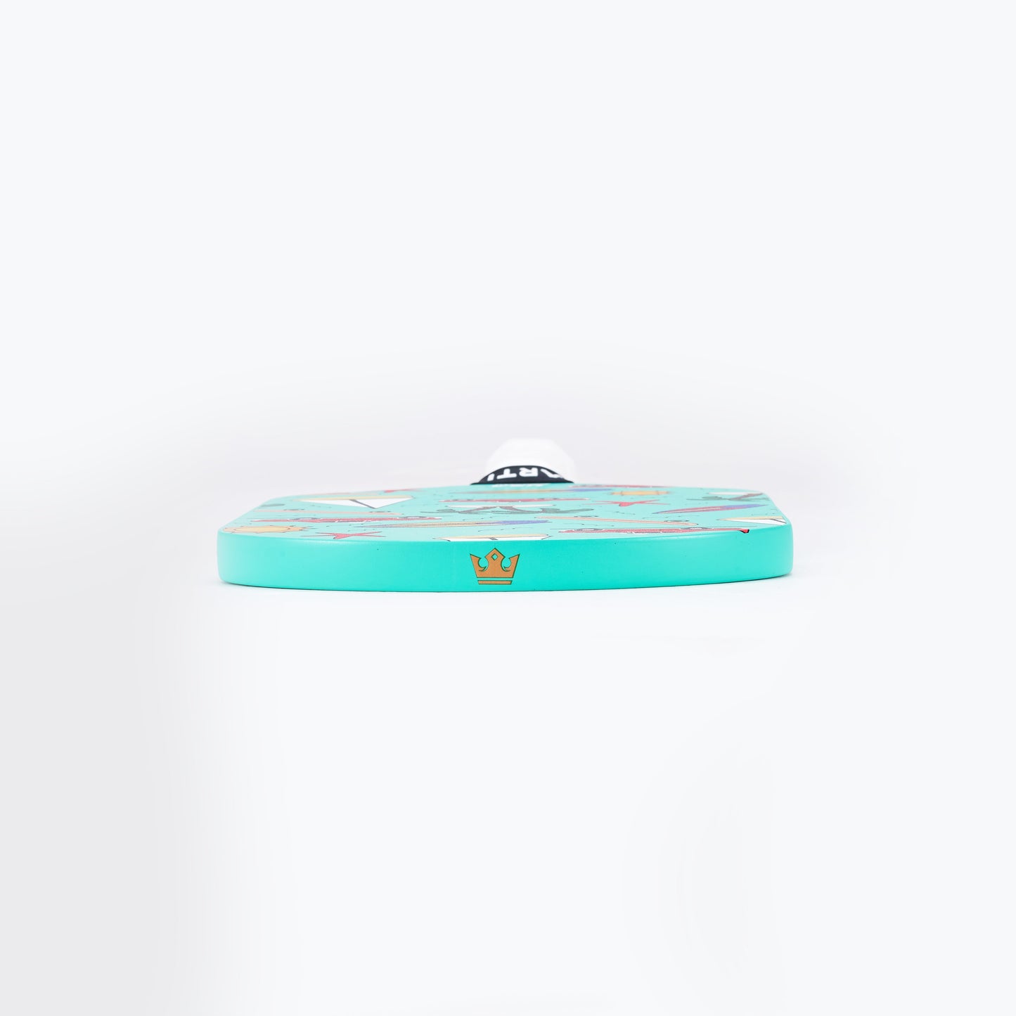 The ARTI Carbon Fiber "CALIFORNIA" paddle by ARTI lies flat and edge-on over a white background, showing its round turquoise face with subtle colorful designs and a centered gold crown emblem on the visible edge.