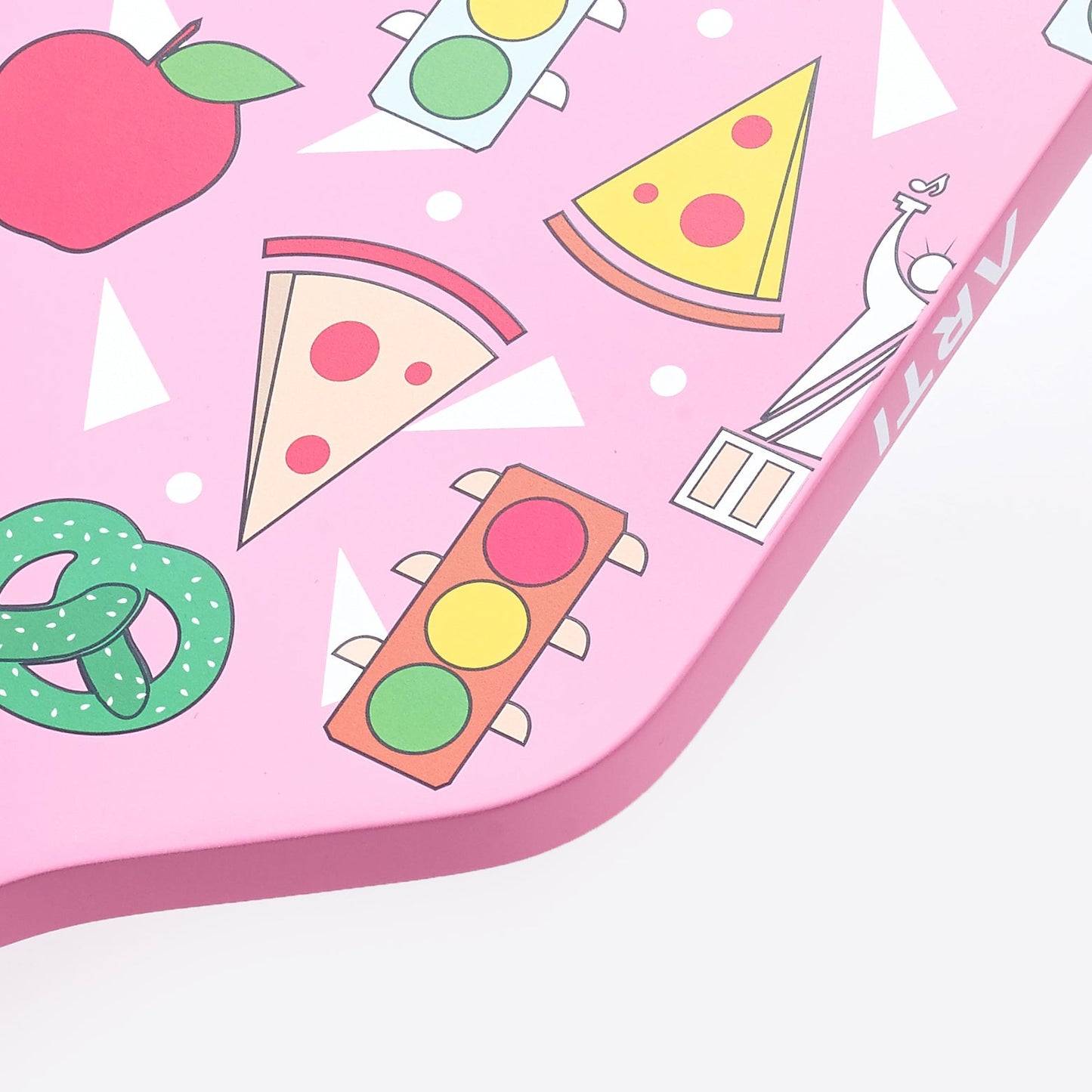 The ARTI Carbon Fiber "NEW YORK" Paddle features pink with cartoon icons—a green pretzel, traffic lights, pizza slices, red apple, and Statue of Liberty—plus black outlines and white triangles, giving New York flair to this USAPA-approved paddle.