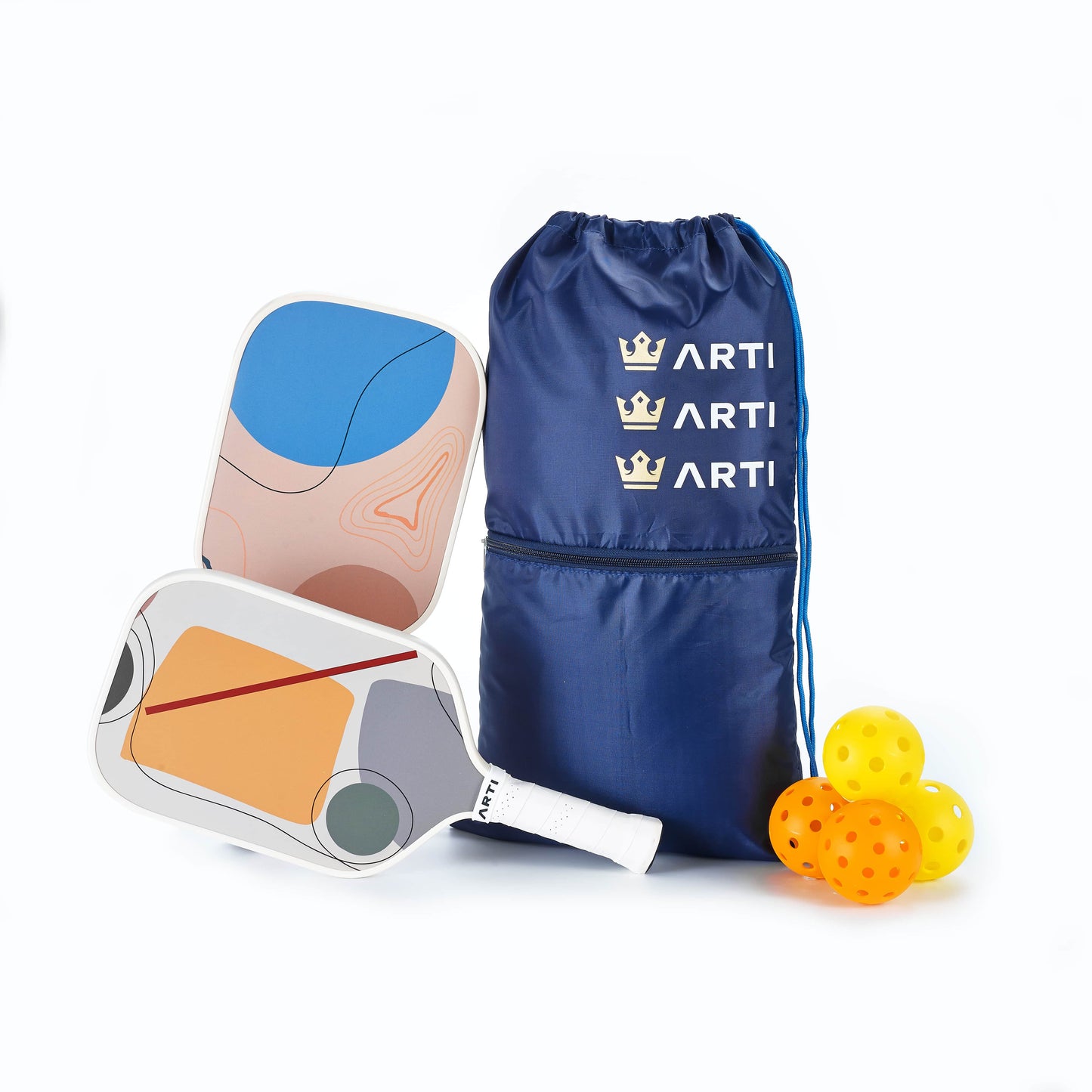 The ARTI Fiberglass "Horizon Duo" Pickleball Paddle Set includes two graphic paddles, a navy ARTI crown drawstring bag, a white abstract-pattern case, and four yellow pickleballs. USAPA approved. Brand: ARTI.