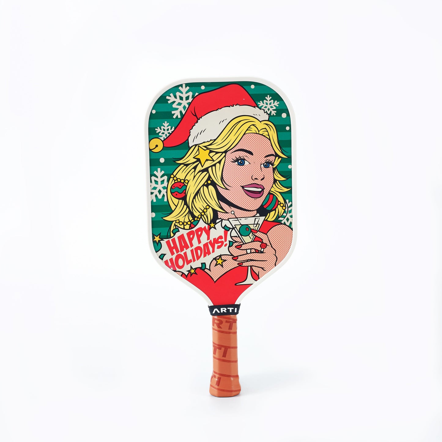 The ARTI Carbon Fiber Kristen&Kristy "Happy Holidays" Paddle features pop art of a blonde in a Santa hat sipping a drink, with snowflakes, ornaments, and “Happy Holidays!” on a vibrant background. Brown handle with black tape at the top.