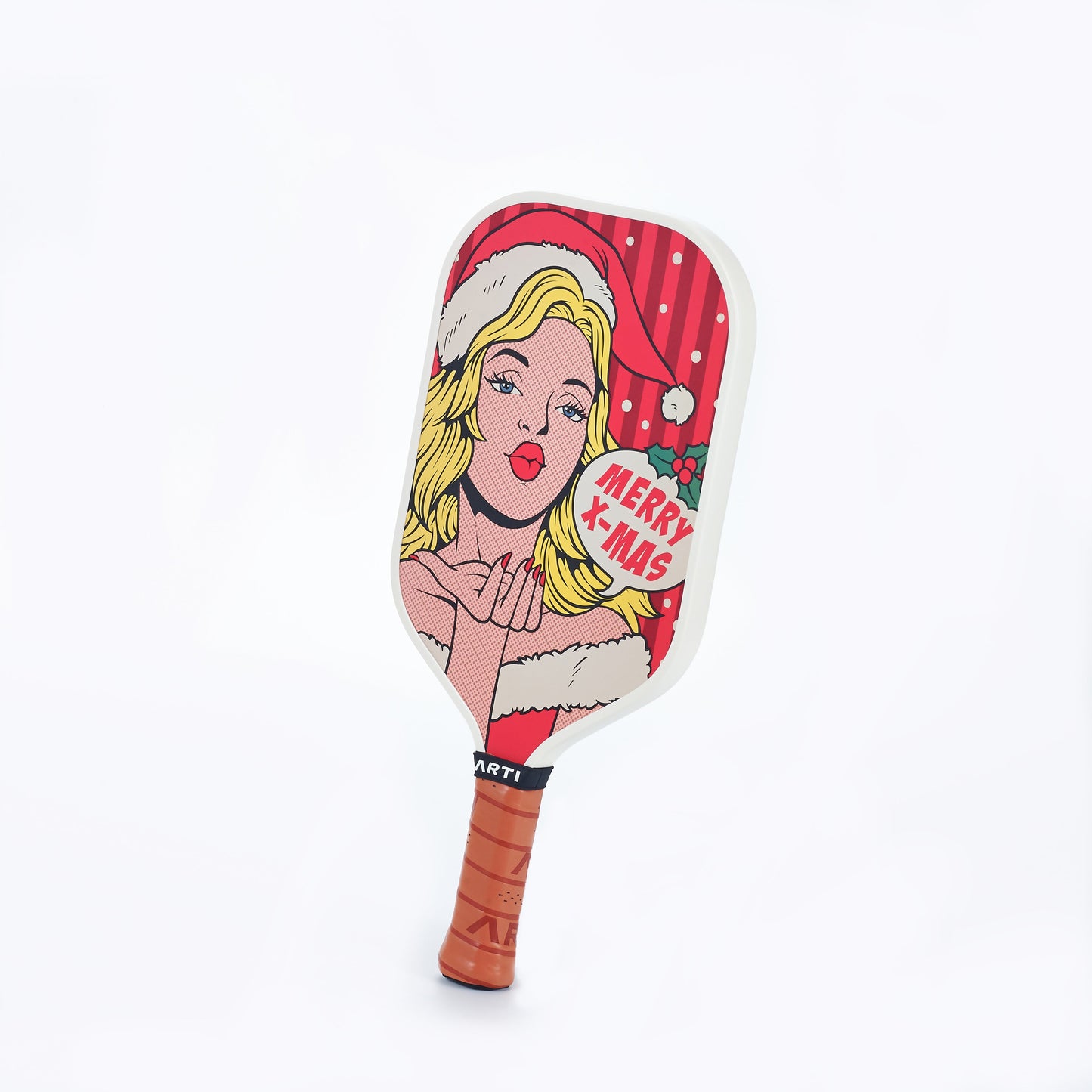 The ARTI Carbon Fiber Kristen&Kristy "X-MAS" paddle by ARTI is USAPA approved and features a pop art blonde in a Santa hat blowing a kiss with “Merry X-Mas” text, holly, white dots on red, and a brown grip tape handle.