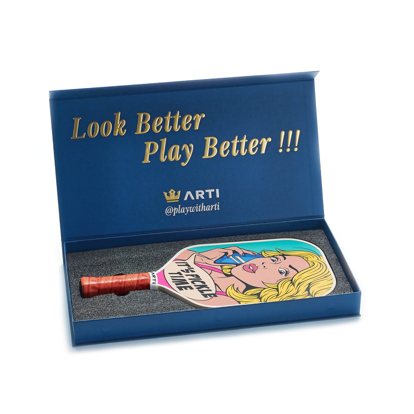 A blue box with gold “Look Better Play Better !!!” text contains the ARTI Carbon Fiber Kristen & Kristy "IT'S PICKLE TIME" pickleball paddle, USAPA approved, featuring pop art of a blonde woman, ARTI crown logo, and @playwitharti.