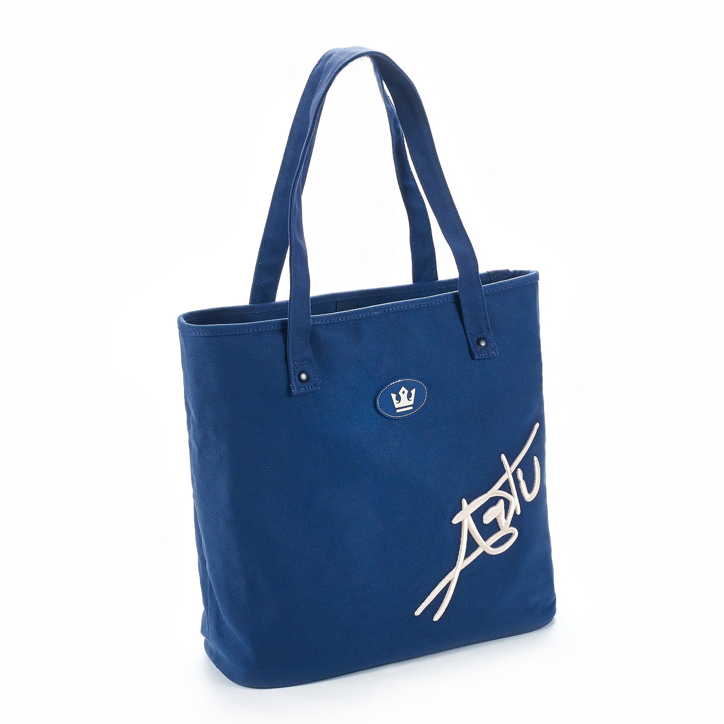 The ARTI Navy Tote Bag by ARTI features two handles, a small crown emblem, and bold white “ASTU” text diagonally on eco-friendly cotton—a stylish choice that stands out against a plain white background.
