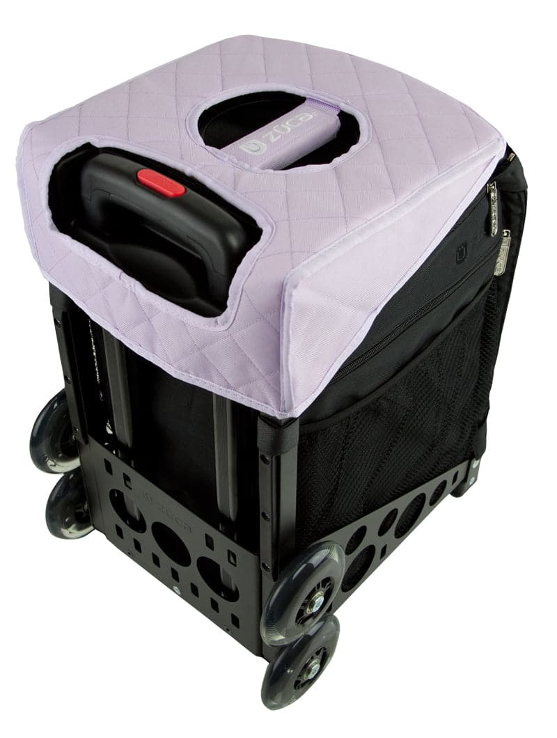 A black rolling crate with side handles and four wheels features a ZUCA Reversible Seat Cushion in quilted light purple. The lid has a central hand slot, and mesh side pockets make this crate a practical ZUCA accessory.