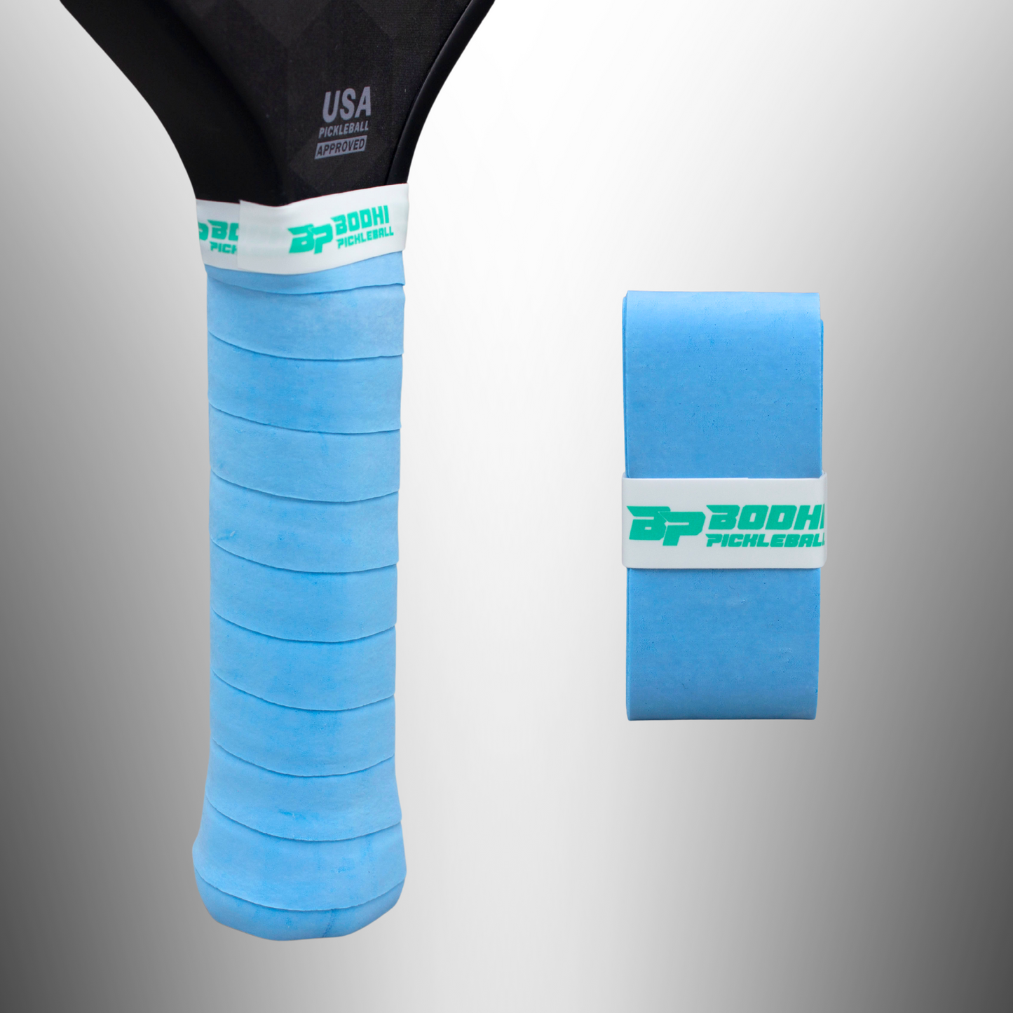 A close-up shows a Bodhi Performance DRYtack™ Premium Pickleball Overgrip in light blue on a paddle handle, with an unused overgrip roll beside it. Both display a white band with green branding, set against a light gray gradient background.