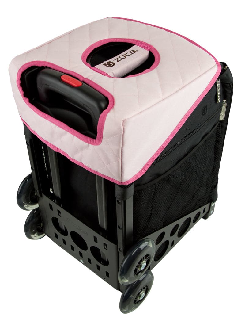 A black rolling bag with a pink quilted cover, sturdy metal frame with circular cutouts, mesh side pockets, four wheels, and a retractable handle. Compatible with the ZUCA Reversible Seat Cushion or other ZUCA accessories.