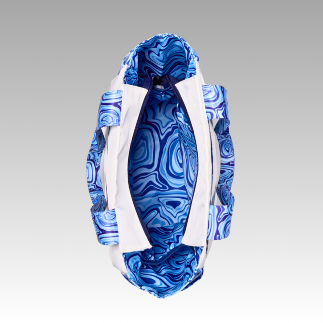 The Lulu Pickleball Tote by Playly Store features a white exterior with blue swirled straps and lining. Viewed from above, its open main compartment reveals an abstract marbled blue and white interior set against a plain gray background.