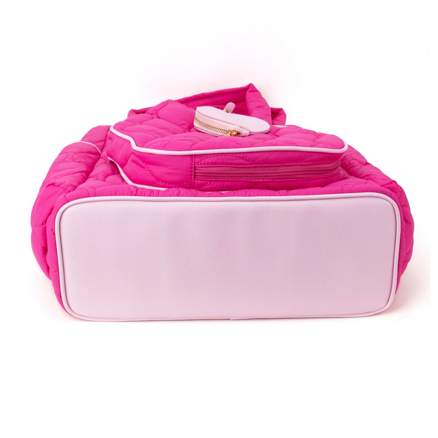The Fifth Ave Pickleball Convertible Tote Bag/Backpack by Queen of the Court is shown from the bottom on a white background. This bright pink, quilted bag features a light pink base, white piping, an exterior zip pocket, and a round zip pouch.