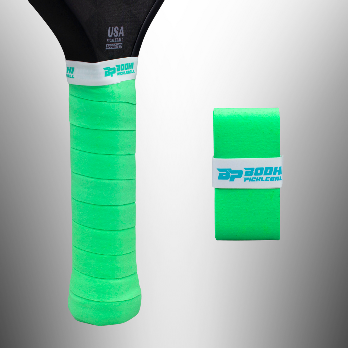 Close-up of a black pickleball paddle handle wrapped in bright green DRYtack™ Premium Pickleball Overgrips by Bodhi Performance, finished with a white band. To the right, a roll of the same grip tape sits against a gradient gray background.