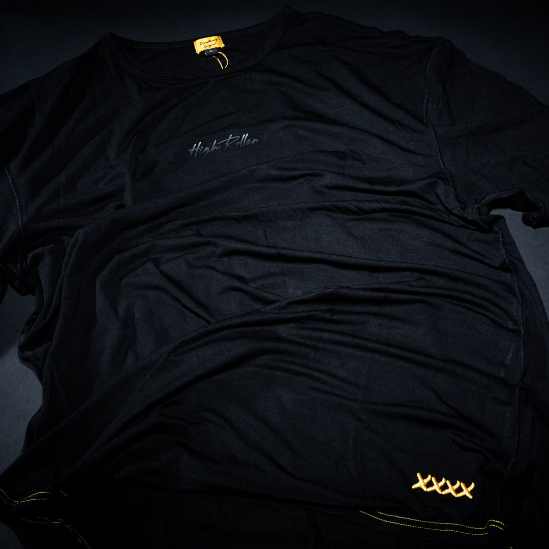 The High Roller Lounge Pickleball T-Shirt by Dope Pickleball Co. features subtle "Hype Killer" chest text, four gold embroidered X's near the hem, and a yellow collar tag for premium detail, all on a black shirt inspired by pickleball culture.