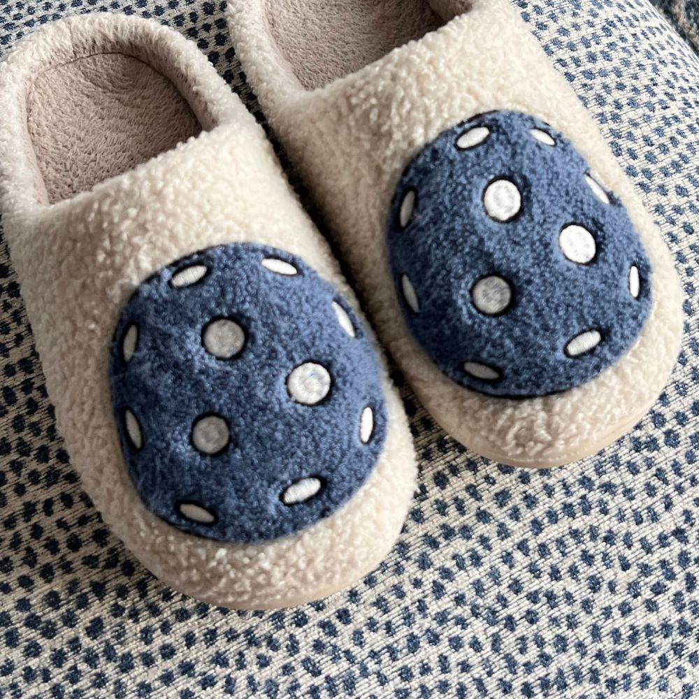 Fresh Pickle’s Pickleball Slippers feature a fuzzy cream design with large blue patches topped with six white polka dots each, placed on textured blue dotted fabric—perfect comfort after your pickleball games.