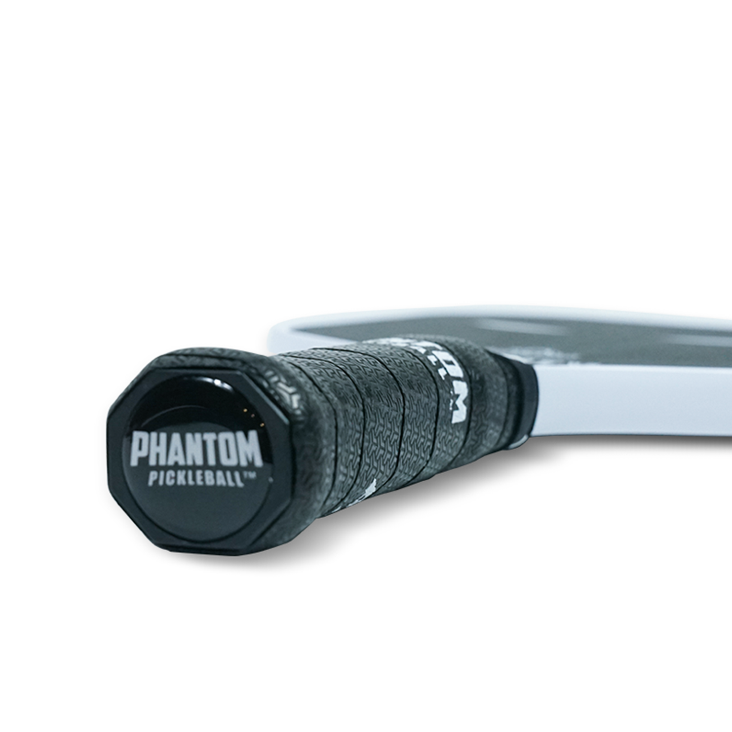Close-up of a Phantom TRINITY 14MM T700 Raw Carbon Fiber Thermoformed Pro Pickleball Paddle handle. The black textured grip and cap, showing "Phantom Pickleball" in white, appear against a clean white background.