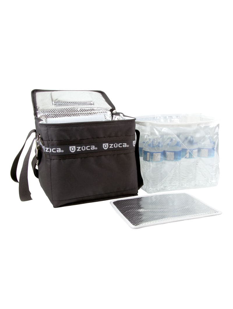 A black ZUCA Cooler is open, revealing a silver insulated lining. Beside it sits a removable clear plastic insert with water bottles, and a silver insulated mat or divider is positioned in front of the bag.