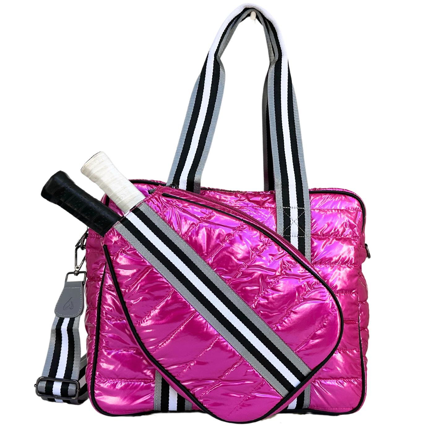 The Queen of the Court Kelsey Pickleball Bag is a shiny, quilted hot pink tote with black and white striped straps, a dedicated external pocket for two rackets, an adjustable shoulder strap, and glossy reflective material.
