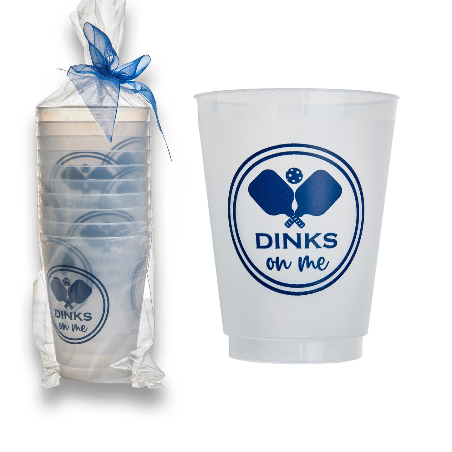 Fresh Pickle’s Pickleball Roadie Cups are shatterproof plastic cups featuring a blue logo with crossed paddles, a ball, and “DINKS on Me.” The reusable cups come bundled in clear wrap with a blue ribbon, shown next to a close-up.