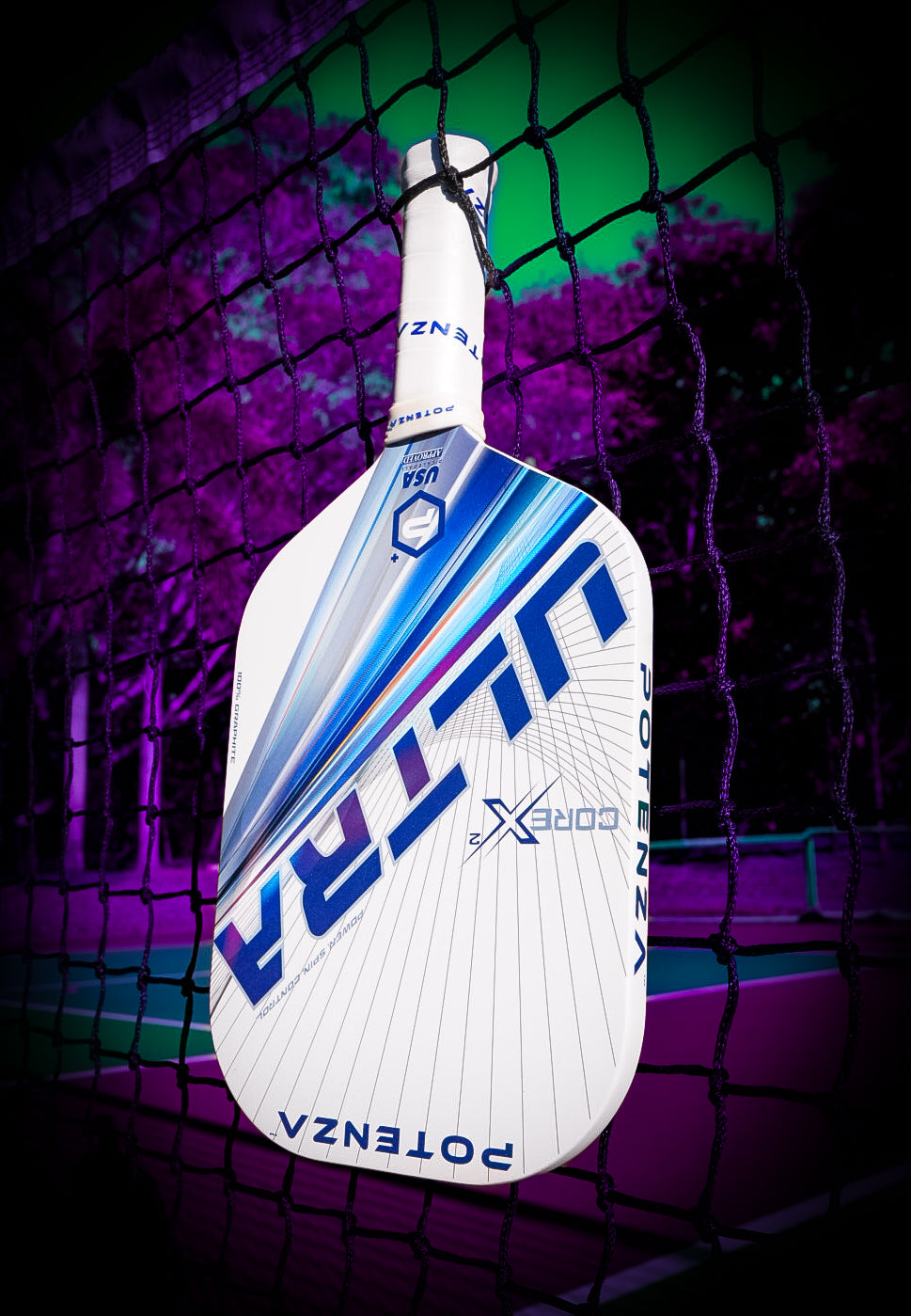 A white Potenza Pickleball ULTRA+ COREx2 edgeless paddle hangs on a net. The neon purple and green court with trees creates a vibrant, futuristic vibe that highlights the paddle's striking blue graphic design.