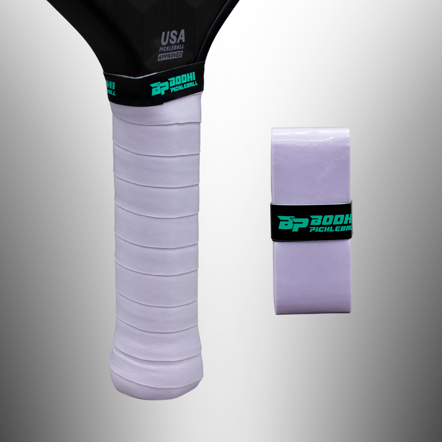 A close-up of a Bodhi Performance PROtack™ Premium Pickleball Overgrip on a paddle handle, with an unused overgrip roll beside it secured by a black band featuring the brand’s teal and white logo, set against a gray gradient background.