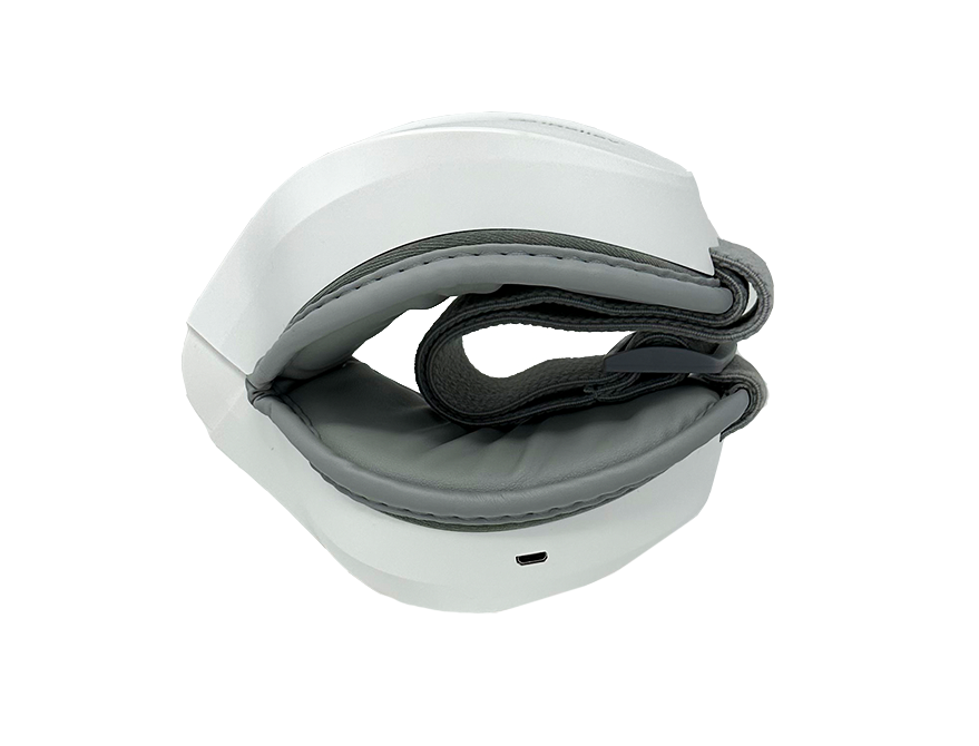 The iReliev Relaxable™ Eye Massager with Heat is a white and gray electronic device featuring padded, curved sections and a front USB port. Designed for hand or wrist use, it is shown against a plain white background.