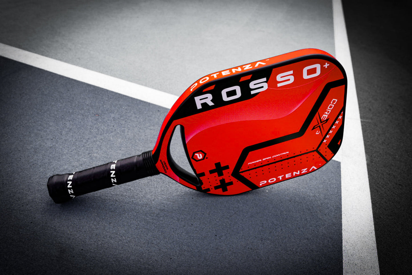 A bright red Potenza Pickleball ROSSO+ COREx3 paddle with black accents and bold COREx3 lettering lies diagonally on a blue and white court, handle left. With a 21mm thick build, it’s designed for players who demand top performance.