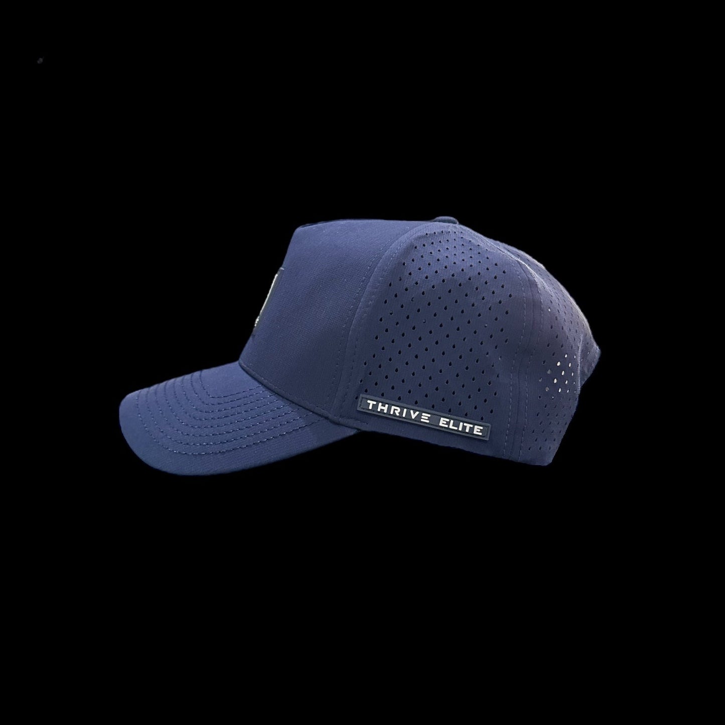The Thrive Elite Tour Hat by Thrive Pickleball is a navy blue baseball cap with a curved brim, perforated side panels, and a rectangular THRIVE ELITE label above the ear—ideal performance headwear shown on a black background.