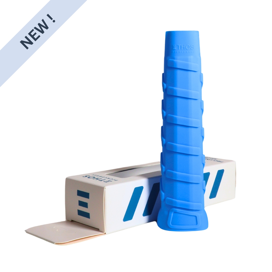 A blue, textured Ethos Pro Undergrip RH-LW by Ethos Pickleball stands upright beside a white box with blue stripes and “ETHOS” branding. The partially open box shows a “NEW!” label; the grip is right-hand specific, lightweight, and vibration-reducing.