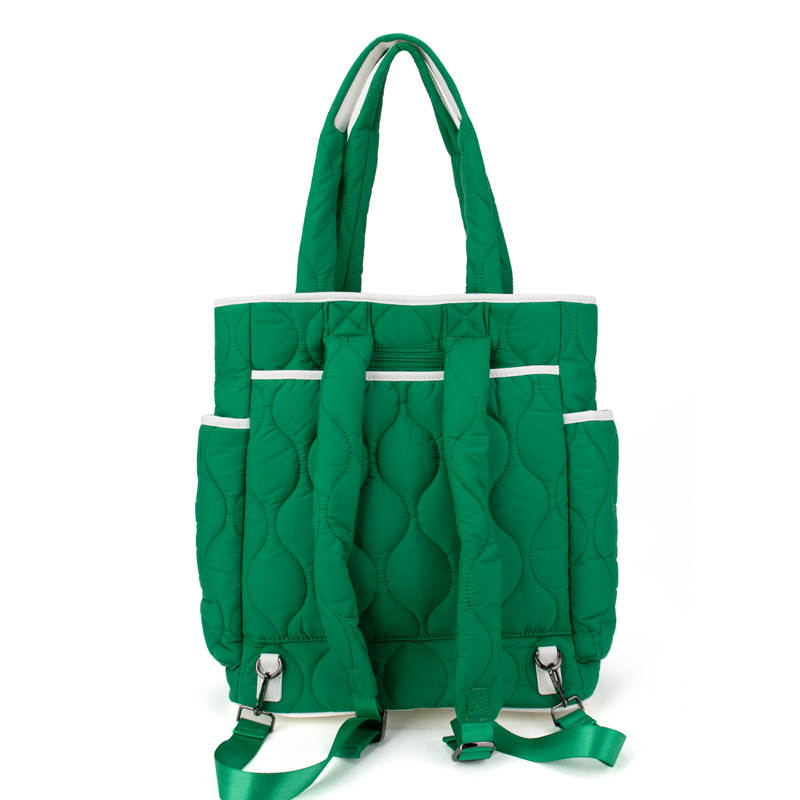 The Queen of the Court Park Ave Tennis Convertible Bag/Backpack features a green quilted design, white trim, two top handles, adjustable backpack straps, and multiple pockets. The bag stands upright against a plain white background.