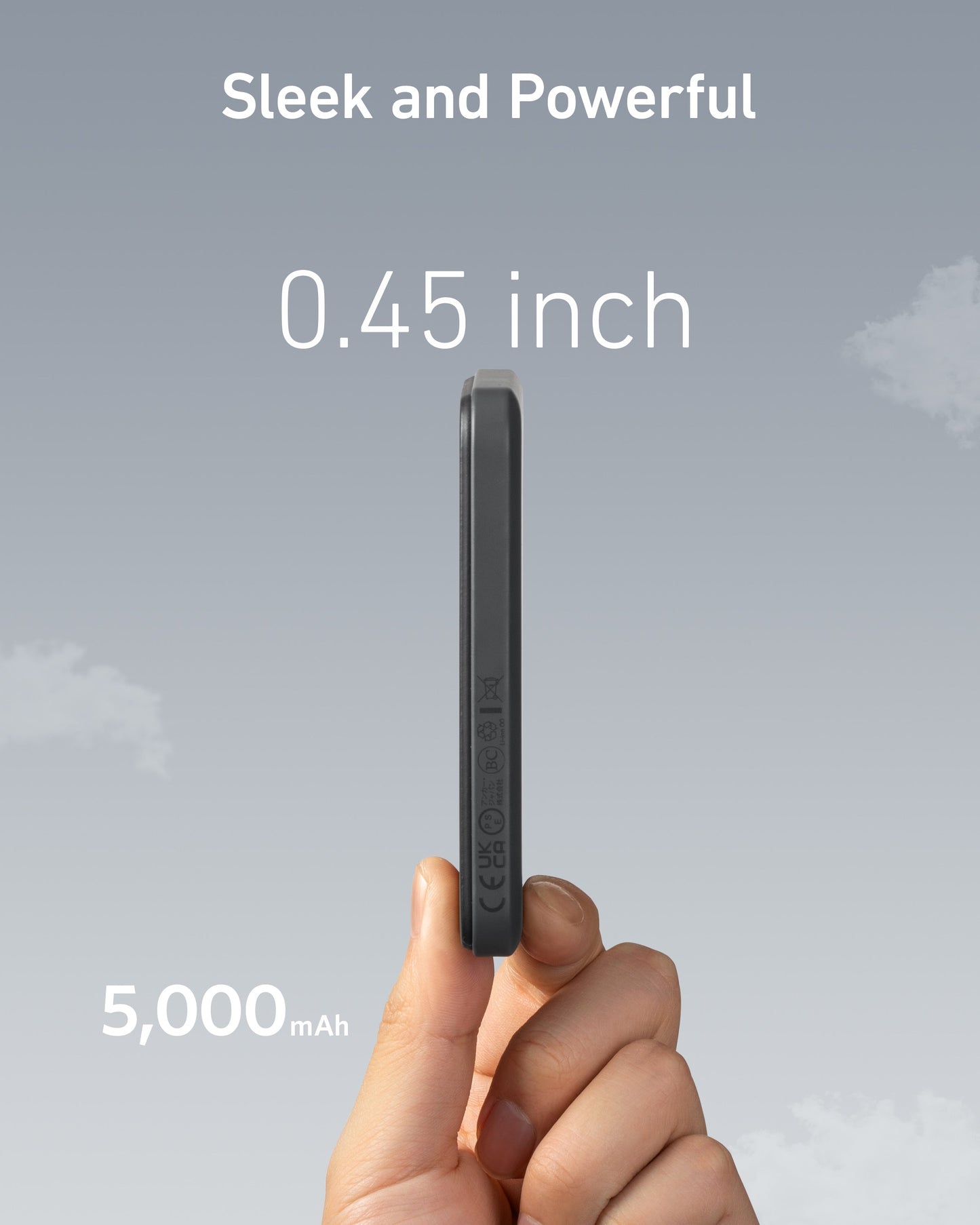 A hand holds the slim, black Anker 621 Magnetic Battery (MagGo) vertically against a cloudy sky. Text above reads “Sleek and Powerful,” with “0.45 inch” for its thinness and “5,000 mAh” noting the battery’s capacity from Anker.
