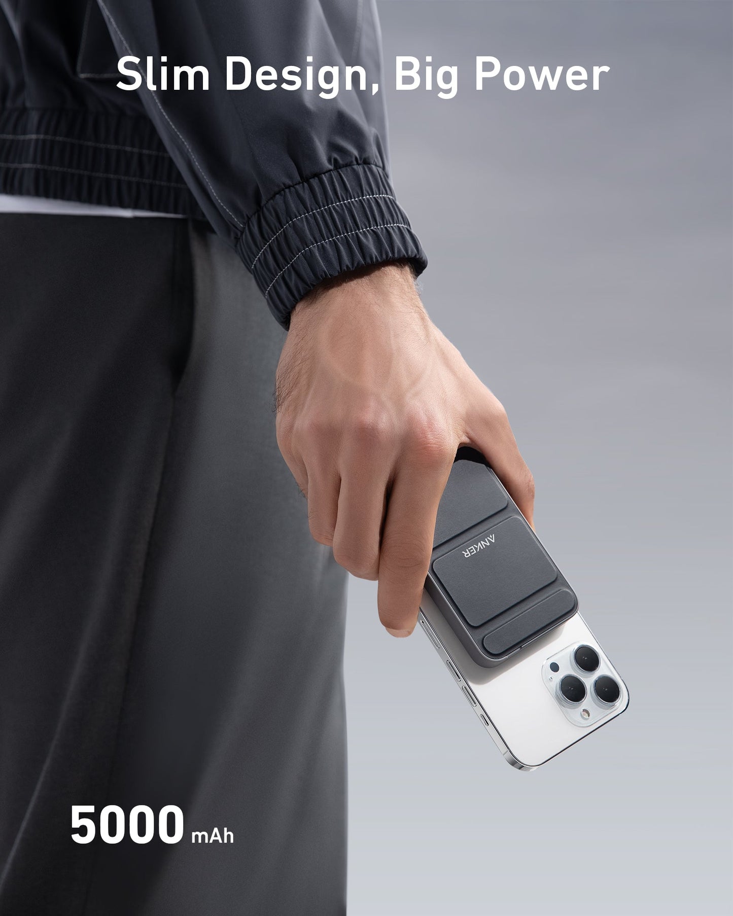 A person in a dark jacket holds a white phone with an Anker 622 Magnetic Battery (MagGo) by Anker attached. The background is light gray. Text above says "Slim Design, Big Power," and below, "5000 mAh" appears in bold white letters.