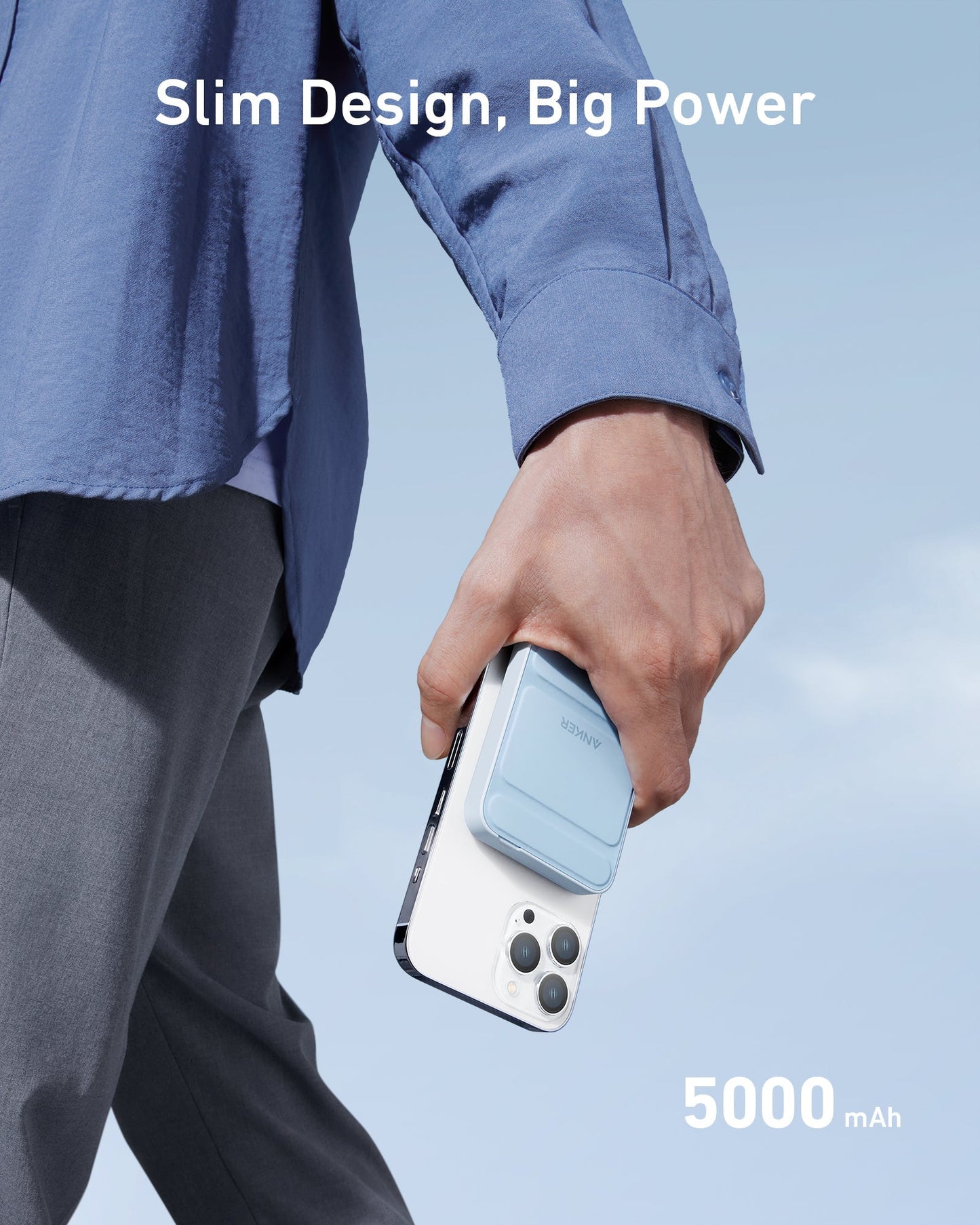 A person in gray pants and a blue shirt holds an Anker 622 Magnetic Battery (MagGo) by Anker, attached to a white phone. The image features “Slim Design, Big Power” at the top, “5000 mAh” at the bottom, and a clear sky background.