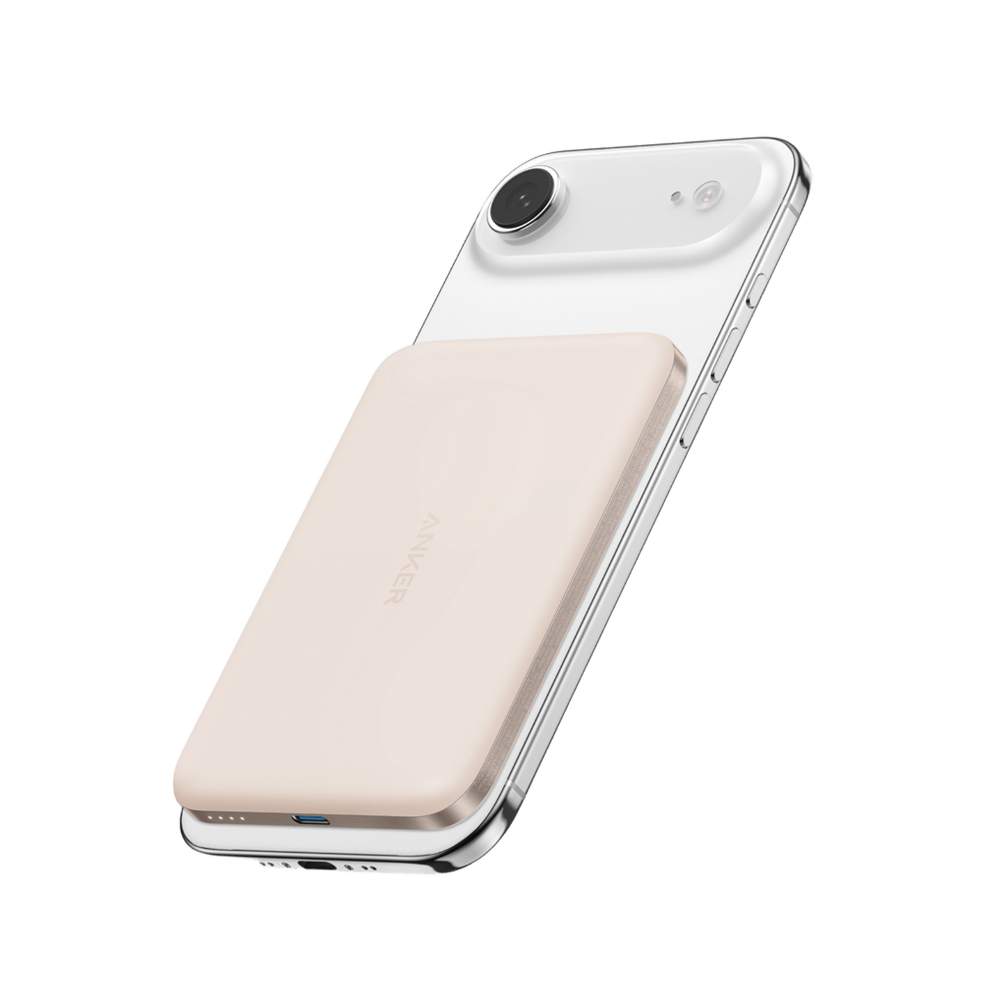 An Anker Nano Power Bank (5K, MagGo, Slim) in cream is magnetically attached to a white smartphone, highlighting its MagSafe-compatible charging on a plain white background with the phone's camera and slim design in view.