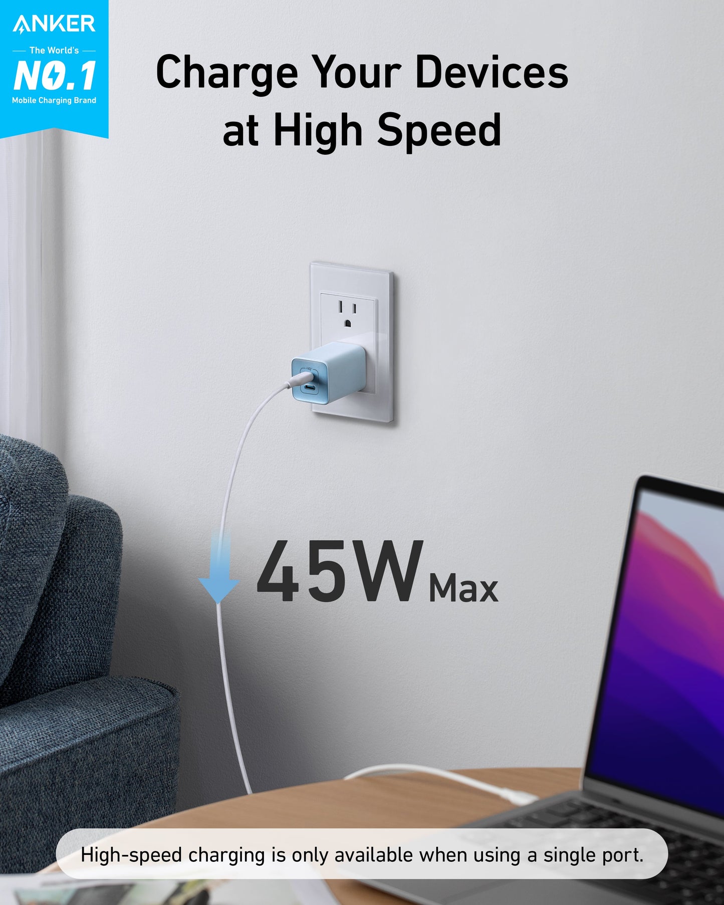 A light blue Anker 523 Charger (Nano 3, 47W) is plugged into a wall socket above a gray armchair, charging a laptop on a desk. Fast Charging for Your Devices. Up to 47W. Note: high-speed charging available via single port only.