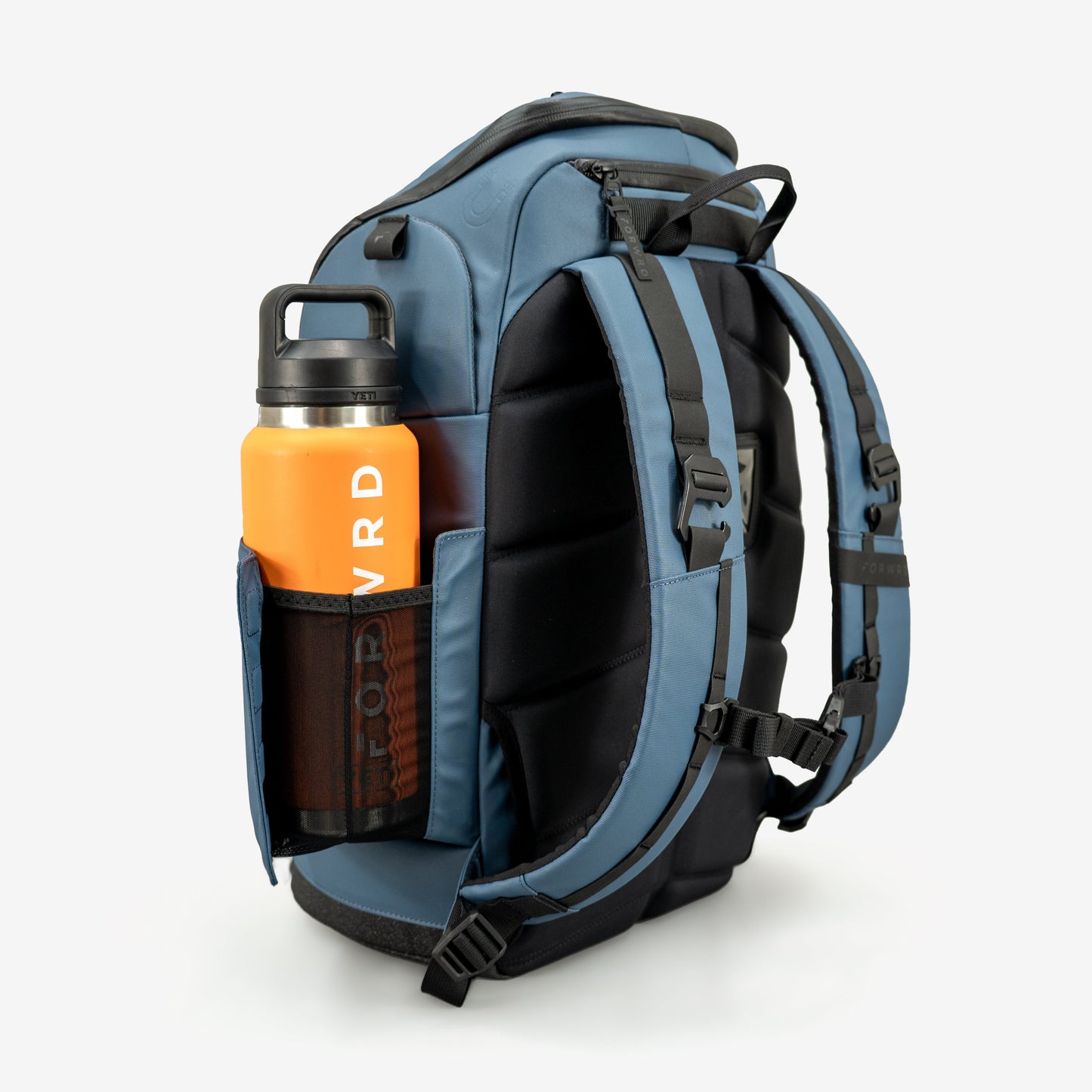 The FORWRD Court Caddy Pickleball Bag stands upright, featuring padded shoulder straps, a water bottle pocket with an orange HYDR bottle, and black buckles and zippers. Made from premium materials, this blue and black bag suits any player’s needs.