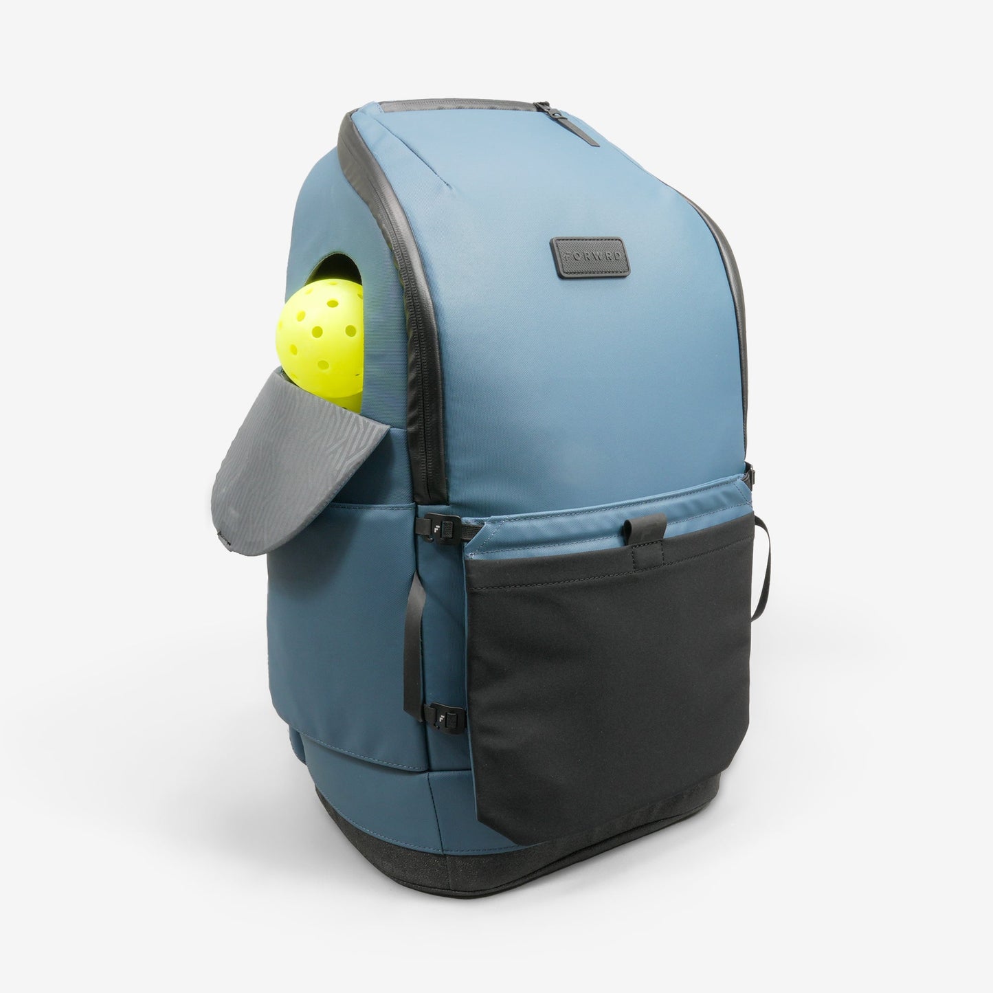 The FORWRD Court Caddy Pickleball Bag in blue and black stands upright with a side pocket open to reveal a yellow perforated ball. It features premium materials, a rectangular black label, and a front pocket against a white background.
