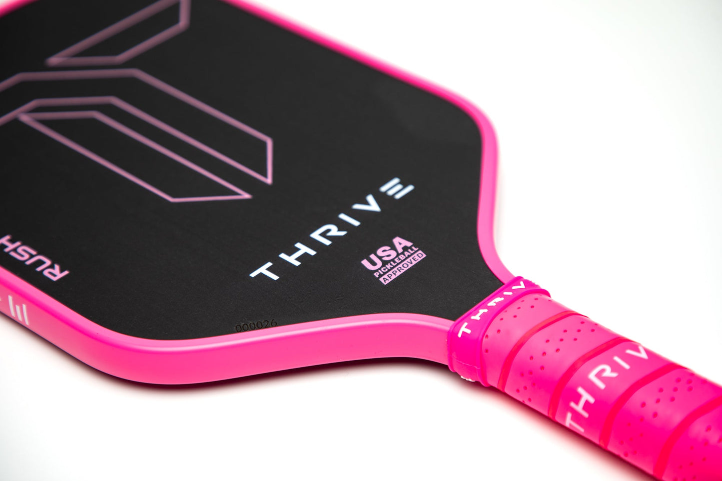 Close-up of a Thrive Pickleball RUSH 13 (PINK) elongated paddle with “USA PICKLEBALL APPROVED” by the grip, bright pink accents, and TORAY T700 carbon fiber. Includes weight card, cover, eraser, and lead weights.