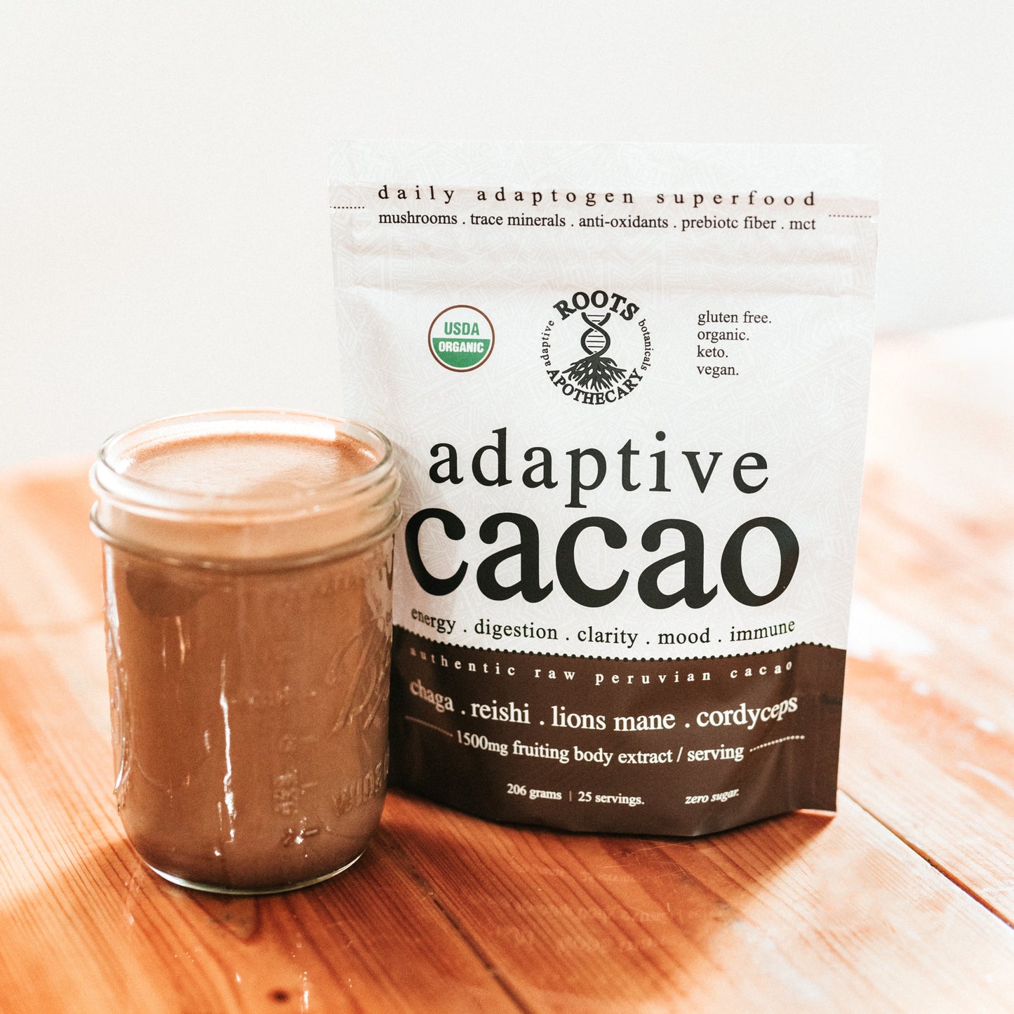 A glass jar of chocolate-hued mushroom adaptogen drink sits next to Roots Apothecary’s “adaptive cacao. performance superfood,” a USDA Organic, gluten-free blend with chaga, ashwagandha, and reishi.