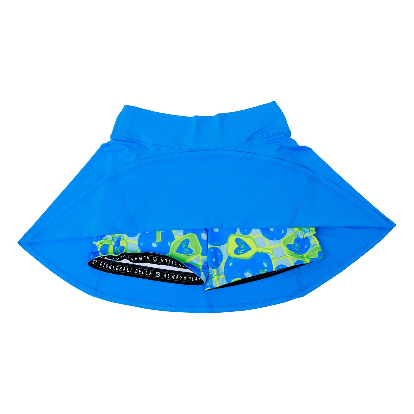 The Pickleball Bella PB Aline Skort Electric Blue with Net Worth features built-in compression shorts with green and blue pickleballs, yellow hearts, and a black waistband reading “PICKLEBALL BELLA ALWAYS FUN.” Shown on a white background.