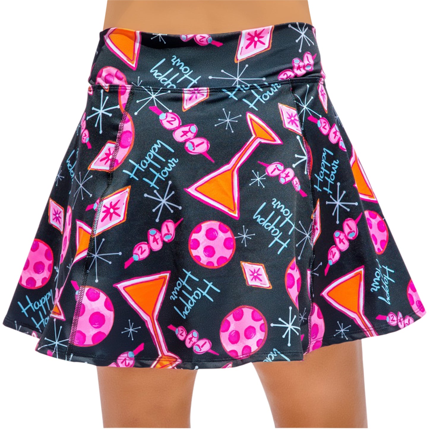 Someone in Pickleball Bella's PB Aline Skort Martini 2-4-1 Happy Hour—a black athletic skirt featuring pink balls, red martini glass triangles, blue “Happy Hour” text, and white and pink starbursts and dots.