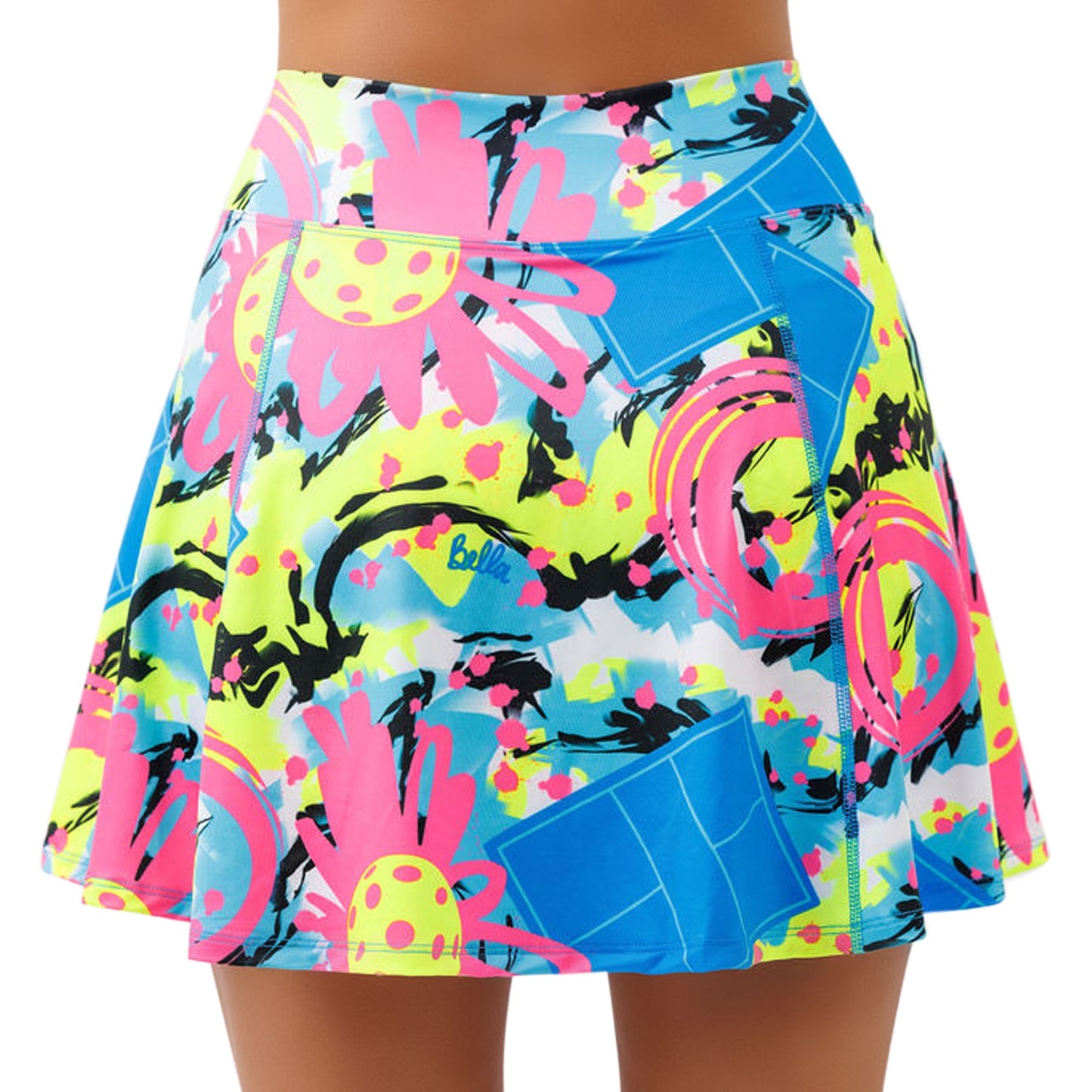 Someone wearing the Pickleball Bella PB Aline Skort Open Play, a colorful high-waisted A-line skort with a bold abstract print in pink, yellow, blue, and black, wide waistband, and built-in compression shorts for comfort.