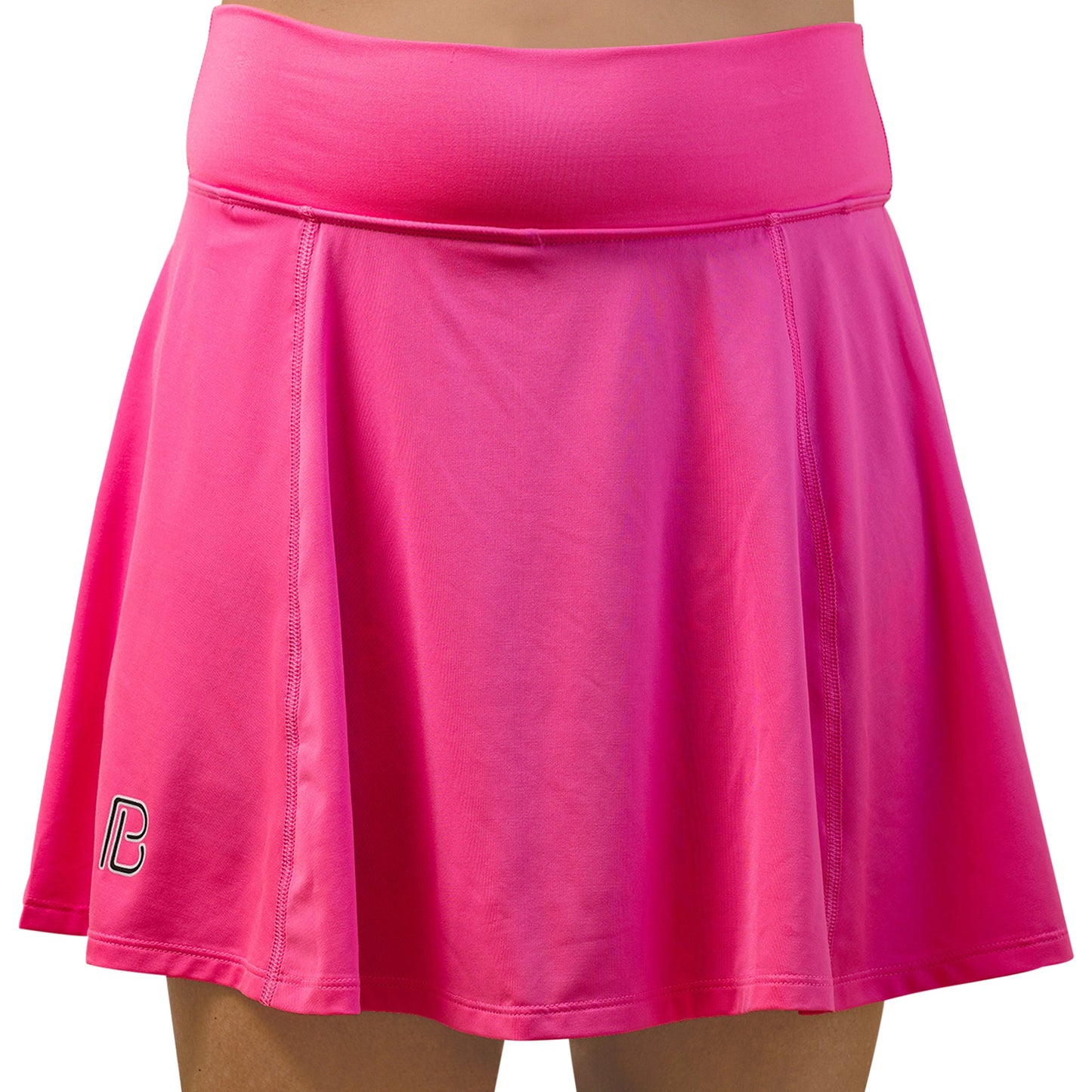 A person wears the Pickleball Bella PB Aline Skort Neon Pink with Groovy, featuring a wide waistband, slight A-line shape, smooth stretchy fabric, built-in compression shorts, and a small white and black logo on the bottom left hem.