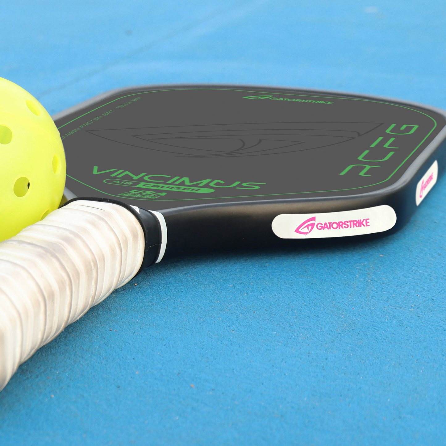 A close-up of GATORSTRIKE™ Weight Tape 10 Pack rests on a blue court beside a yellow pickleball and paddle, highlighting GATORSTRIKE branding—a must-have accessory for customizing your paddle’s balance.