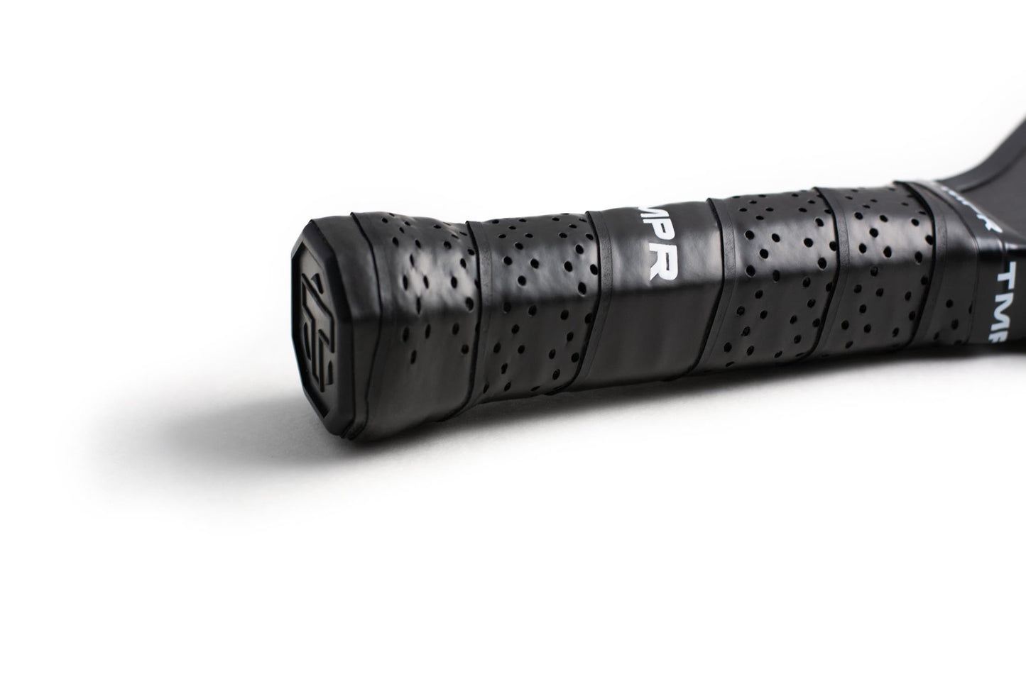 Close-up of the Ascend LX by TMPR Sports—a black pickleball paddle with a long handle, wrapped in perforated grip tape. The textured details and white branding, plus the subtle logo on the end cap, stand out on a plain white background.